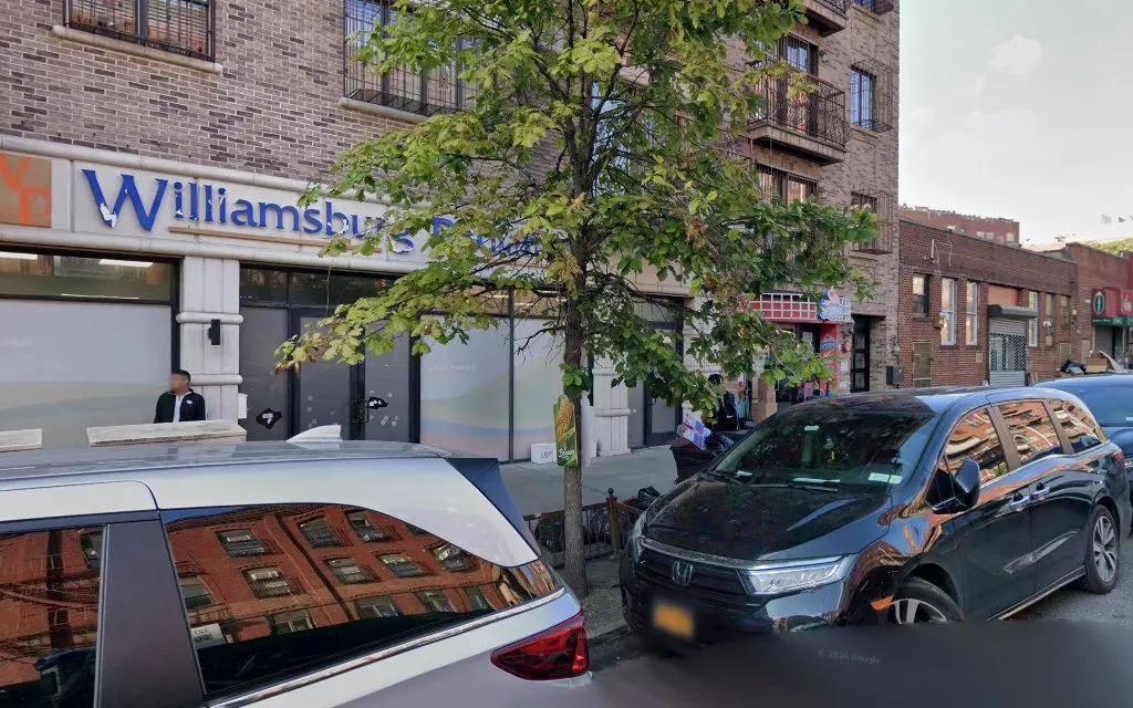 The Williamsburg Pediatrics sign over the street-level entrance on Wallabout Street